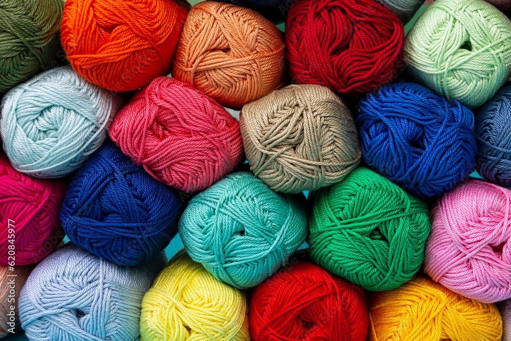 Background of multi-colored skeins of cotton yarn stacked on top of