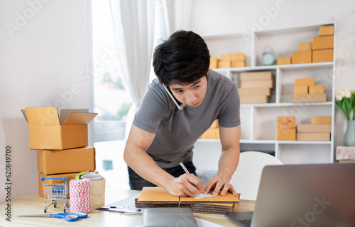 Man Writing Customer Details for Shipping in Home Office, Packing Box and Writing Customer Information for Efficient Shipping, E-Commerce and Online Selling Concept.