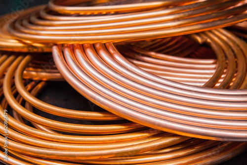 Twisted new copper tubes on a black background.