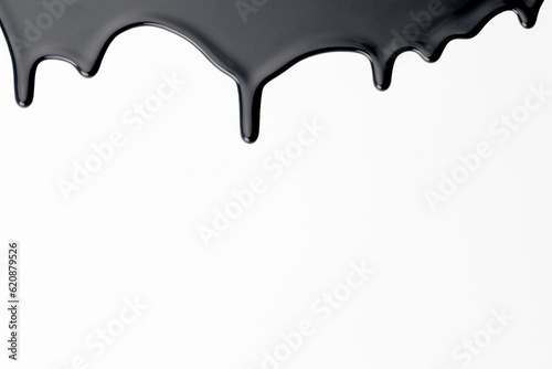 Paint drops flowing down on white paper. Black ink blots abstract background