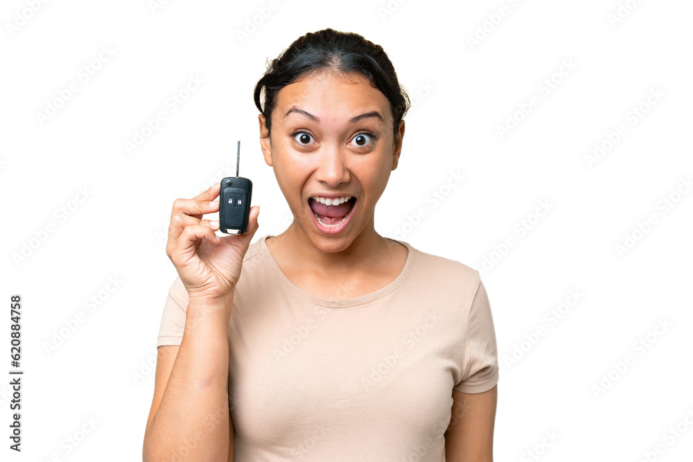 Young Uruguayan woman holding car keys over isolated chroma key background with surprise and shocked facial expression Young Uruguayan woman holding car keys over isolated chroma key background with surprise and shocked facial expression
