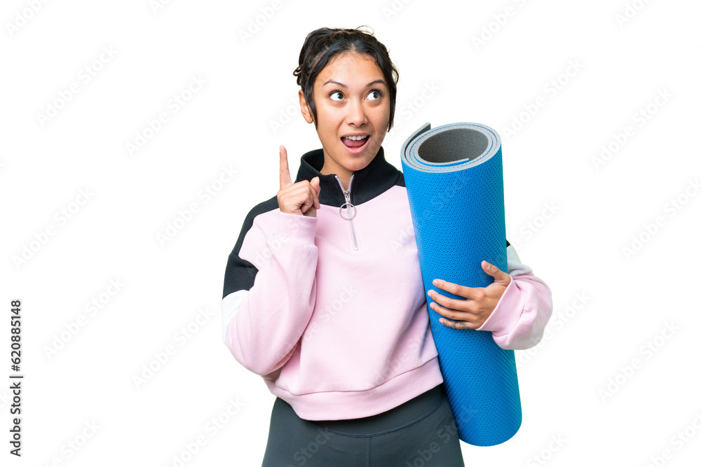 Young sport woman going to yoga classes while holding a mat over isolated chroma key background thinking an idea pointing the finger up Young sport woman going to yoga classes while holding a mat over isolated chroma key background thinking an idea pointing the finger up