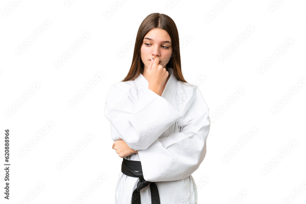 Teenager girl doing karate over isolated chroma key background having doubts Teenager girl doing karate over isolated chroma key background having doubts