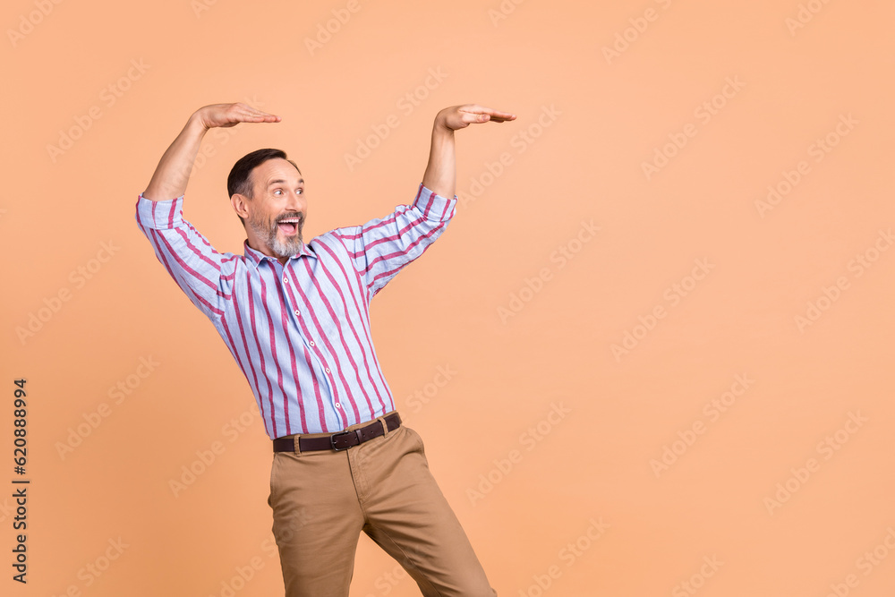 Photo of impressed overjoyed man dancing hands make moves look empty space news isolated on beige color background Photo of impressed overjoyed man dancing hands make moves look empty space news isolated on beige color background
