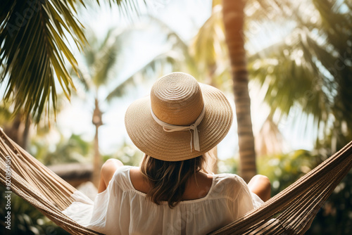 A glimpse of a young stylish woman's back, as she relaxes in a hammock strung between palm trees, her straw hat providing a sense of relaxation Generative AI