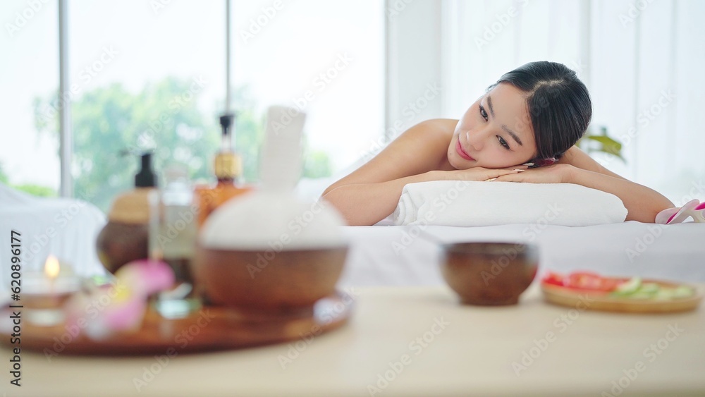 Beautiful young asian woman in towel lying on spa bed waiting spa treatment in weekend at spa salon. Therapy, Body care concept Beautiful young asian woman in towel lying on spa bed waiting spa treatment in weekend at spa salon. Therapy, Body care concept
