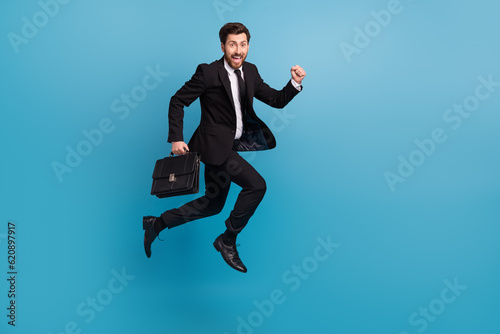 Full body photo of crazy run guy with diplomat suitcase businessman office manager hurry go his interview isolated on blue color background