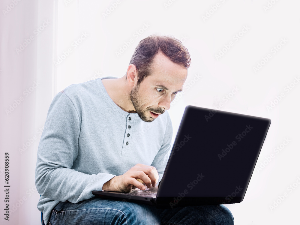 Shocked man in front of his computer. Selective focus