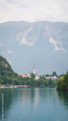 Wonderful pic the church of Bled Lake with the mountains in the background on a cloudy day and its reflection on the water 