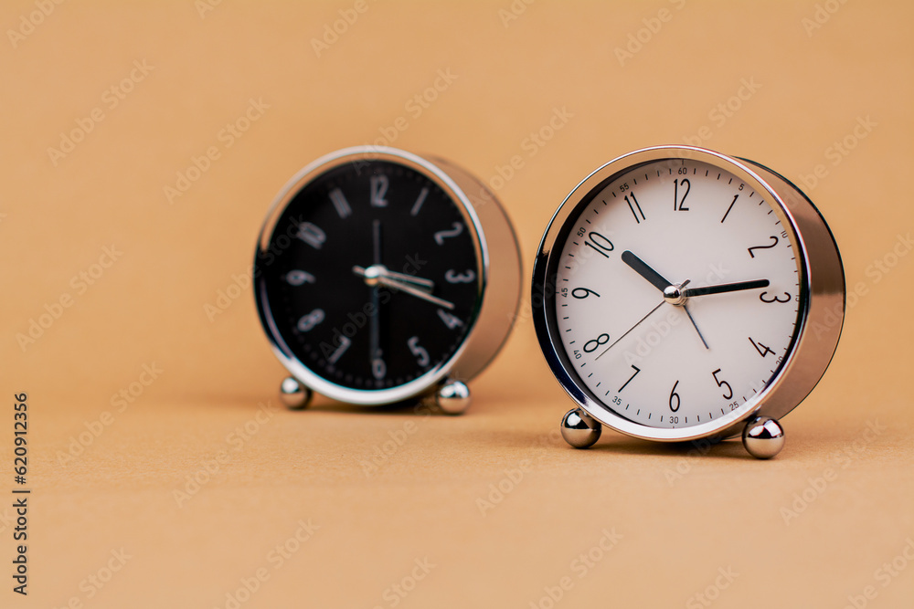 Alarm clock. Beautiful modern clock lies on paper background. time clock time standstill time off work working with time time concept Alarm clock. Beautiful modern clock lies on paper background. time clock time standstill time off work working with time time concept