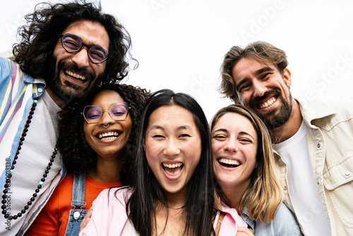 Diverse group of friends taking a selfie in the street. Cheerful multiracial group of young hipsters taking a picture outside and looking at camera.