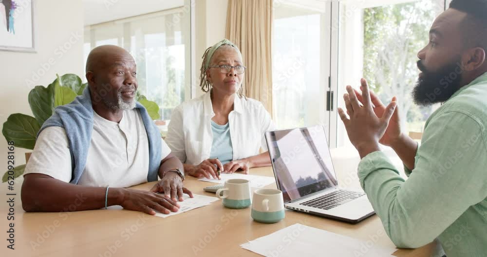 African american financial advisor and senior couple talking at home, slow motion