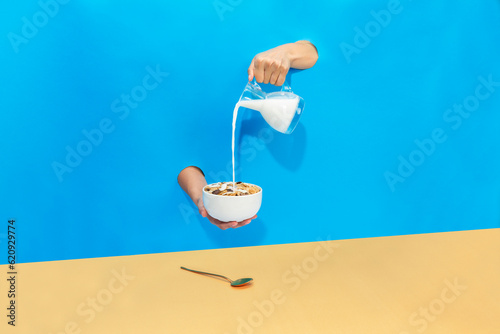 a hand pours milk from a jug into a bowl