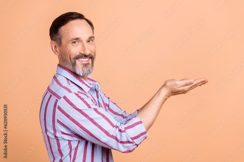 Side profile photo of positive nice person with white gray beard palms presenting offer empty space isolated on pastel color background Side profile photo of positive nice person with white gray beard palms presenting offer empty space isolated on pastel color background