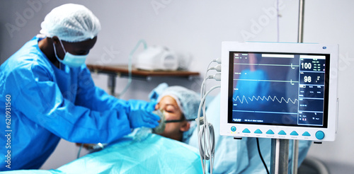 Healthcare, doctor and patient in oxygen mask with monitor for surgery, emergency care and hospital. Breathing, screen and surgeon helping person in operation, digital graphs to check medical results photo