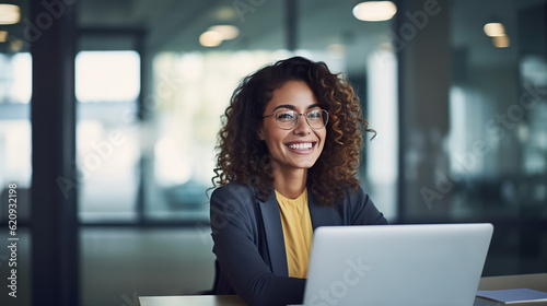 Professional female employee or a businesswoman using a laptop in a modern office. Copy space