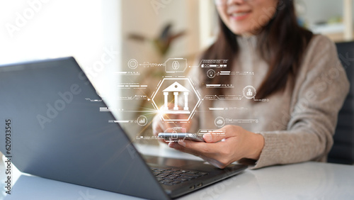 Woman using computer Laptop conducting online financial transactions through the internet. The concept of Mobile Banking or Virtual Banking technology that is convenient, emphasizing safety.
