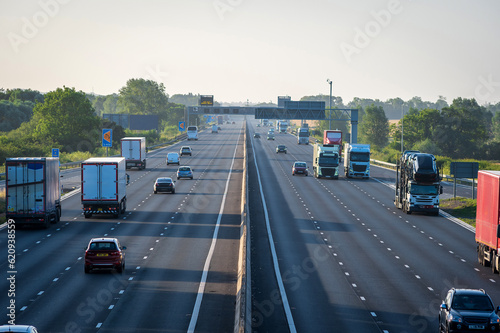 heavy traffic moving at speed on uk motorway in england at sunrise photo