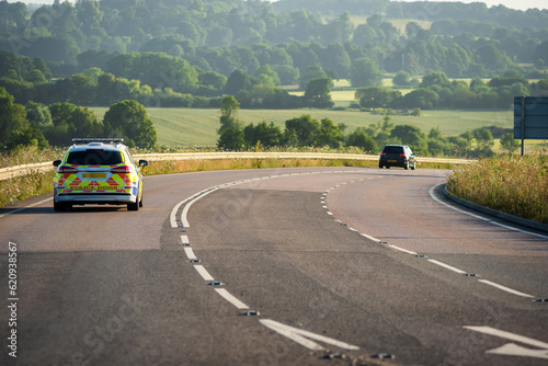 police car moving at speed on uk motorway in england at sunrise photo