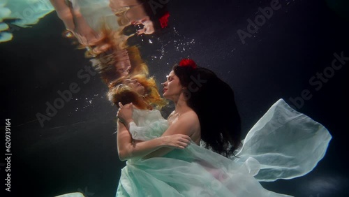 sexy women swimming underwater, slow motion shot with two beautiful ladies in depth, pair lesbians photo