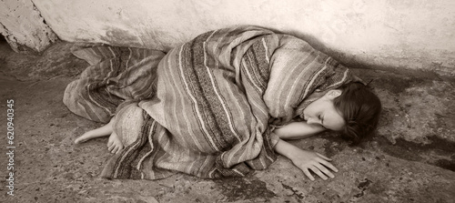 Εκτύπωση καμβά A girl in poor clothes lies on the ground
