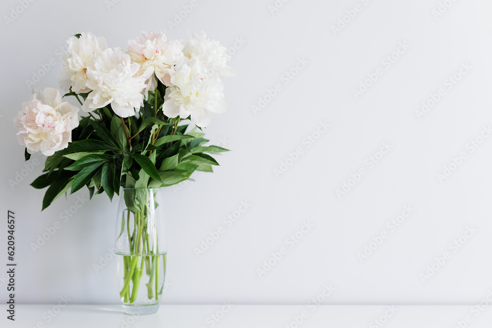 Beautiful fresh white peonies bouquet in vase on the table