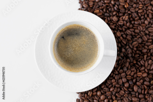 Top view of coffee mug and coffee beans on table with copy space