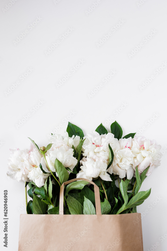 Beautiful white peonies in brown paper bag with copyspace