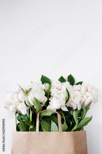 Beautiful white peonies in brown paper bag with copyspace