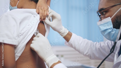 Bild auf Leinwand Male pediatrician listening to child's lungs with a stethoscope, pneumonia