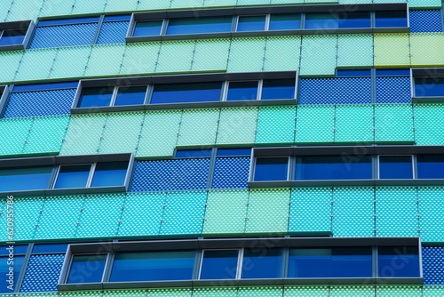 Closeup of a facade of a green and blue modern office building in Arnhem in the Netherlands