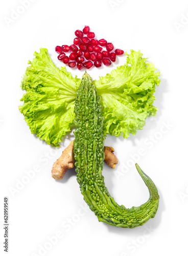 Hindu god Ganpati also known as Lord Ganesha made out of fresh vegetables and fruits on white background. photo