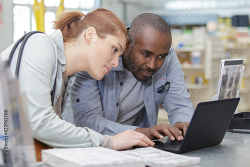 male and female technicians discuss new project while using laptop