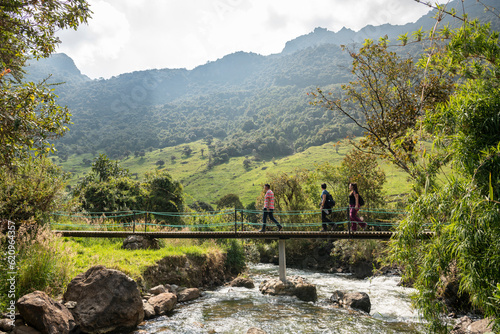 Hikers crossing bridge, Termas de Papallacta, Napo, Ecuador photo