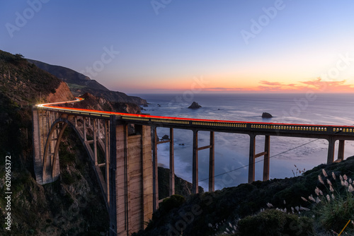 Light trails on Bixby creek bridge on the coast of central California at twilight in autumn