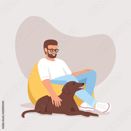 man sitting on a bag chair his dog is with him