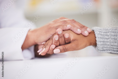 Holding hands, patient and doctor with support, empathy and care in medicine, clinic or hospital worker with woman in crisis. Doctors hand, nurse or person with kindness, solidarity or respect