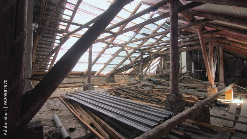 Attic of old building with partly disassembled roof and wooden beam supports. Construction materials and restoration works Attic of old building with partly disassembled roof and wooden beam supports. Construction materials and restoration works