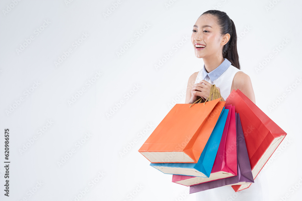 Beautiful Attractive Asian Woman smile and holding shopping bags feeling so happiness and enjoy with black Friday sale in Shopping mall,isolated on white background. Shopping Lifestyle Concept Beautiful Attractive Asian Woman smile and holding shopping bags feeling so happiness and enjoy with black Friday sale in Shopping mall,isolated on white background. Shopping Lifestyle Concept