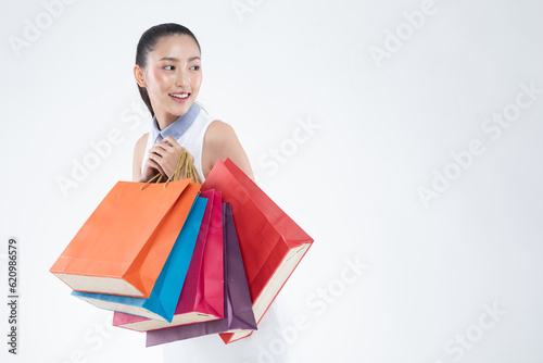 Beautiful Attractive Asian Woman smile and holding shopping bags feeling so happiness and enjoy with black Friday sale in Shopping mall,isolated on white background. Shopping Lifestyle Concept