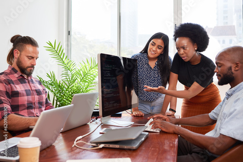 Three developers peer programming together in office, assisting peer review