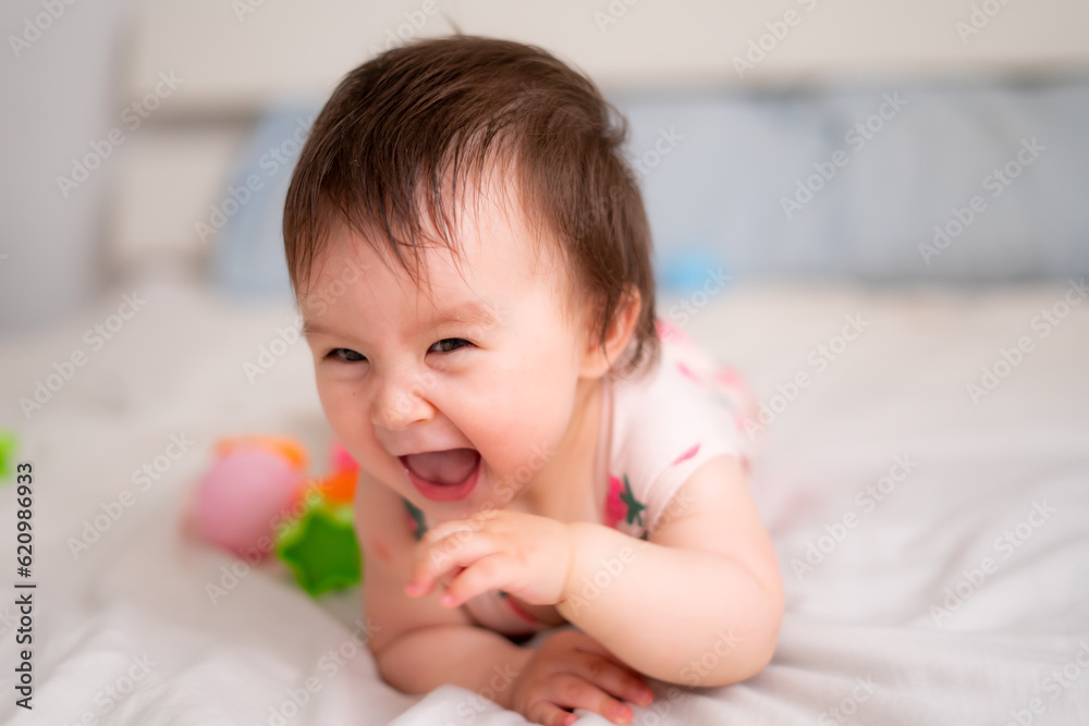 lifestyle home portrait of sweet and adorable mixed ethnicity Asian Caucasian baby girl playing with color blocks on bed excited and happy in childhood concept lifestyle home portrait of sweet and adorable mixed ethnicity Asian Caucasian baby girl playing with color blocks on bed excited and happy in childhood concept
