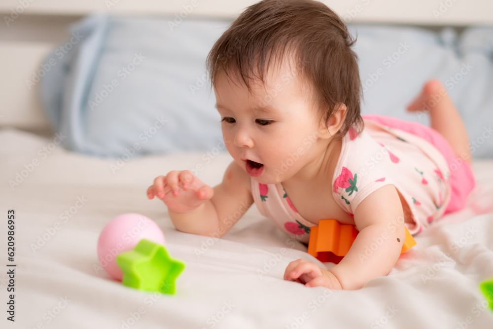 lifestyle home portrait of sweet and adorable mixed ethnicity Asian Caucasian baby girl playing with color blocks on bed excited and happy in childhood concept lifestyle home portrait of sweet and adorable mixed ethnicity Asian Caucasian baby girl playing with color blocks on bed excited and happy in childhood concept