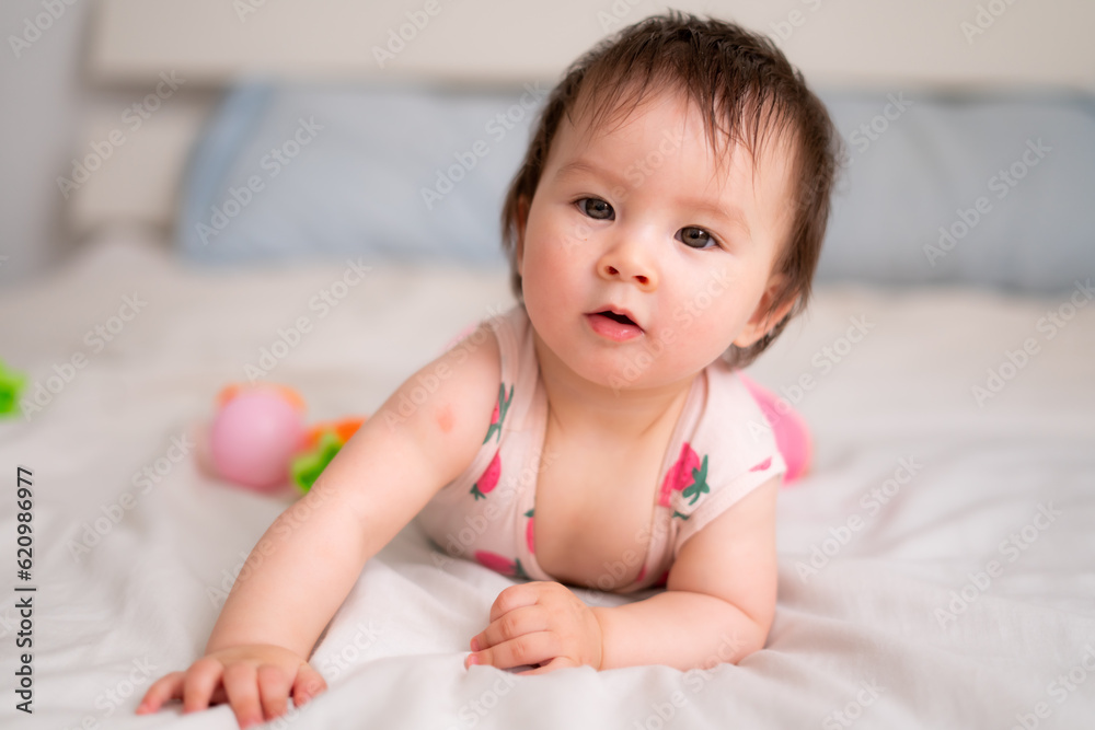 lifestyle home portrait of sweet and adorable mixed ethnicity Asian Caucasian baby girl playing with color blocks on bed excited and happy in childhood concept lifestyle home portrait of sweet and adorable mixed ethnicity Asian Caucasian baby girl playing with color blocks on bed excited and happy in childhood concept