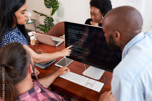 Three developers peer programming together in office, assisting peer review