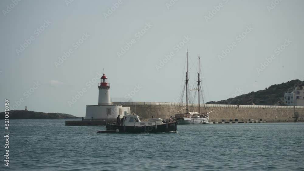 Shot of small boat entering port and Cathedral in background, Ibiza Town, Ibiza, Balearic Islands, Spain Shot of small boat entering port and Cathedral in background, Ibiza Town, Ibiza, Balearic Islands, Spain