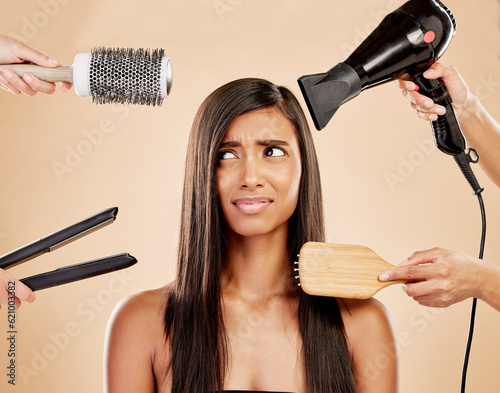 Hair, tools and worry of woman with product for beauty, heat treatment and unhappy on studio background. Indian female model, stress and anxiety for brush, hairdryer and flat iron styling equipment