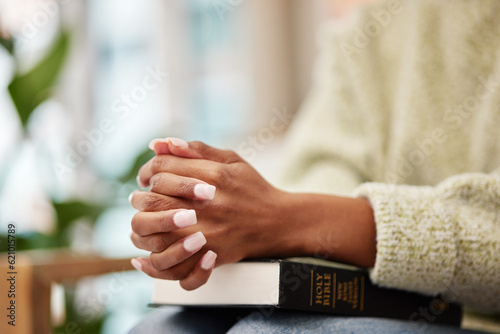 Hands, bible and woman praying for help, faith or gratitude to God, praise and humble in her home. Jesus, worship and lady person in prayer for religious, hope or trust, Christian and spiritual guide © Malik/peopleimages.com