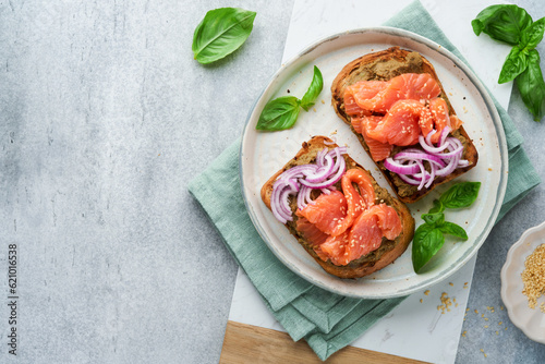 Sandwiches with salted salmon, avocado guacamole, red onions and basil. Smorrebrod. Set of danish open sandwiches. Healthy food, breakfast. Clean eating, dieting, vegan food concept. Top view.