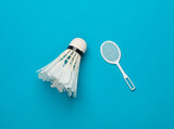 Leisure. Miniature Batbinton racket and shuttlecock on a blue background